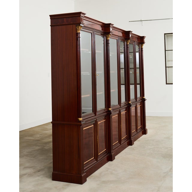 Opulent grand library bookcase cabinet crafted from mahogany in the English regency taste. The two-part case features...