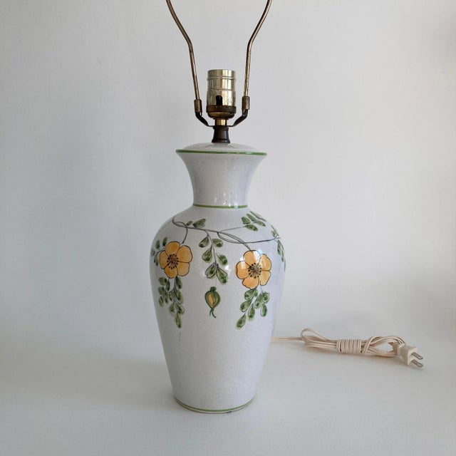 A Made in Italy, ceramic table lamp featuring a floral pattern in yellow and green on a white/ off-white crackle glaze...