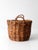 Vintage handwoven wicker basket featuring a rounded form, sturdy woven construction, and twisted loop handles at either...