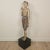 A 19th-century Southeast Asian tall painted and carved wood figure of a man, with wear and losses, on later stand. The man...