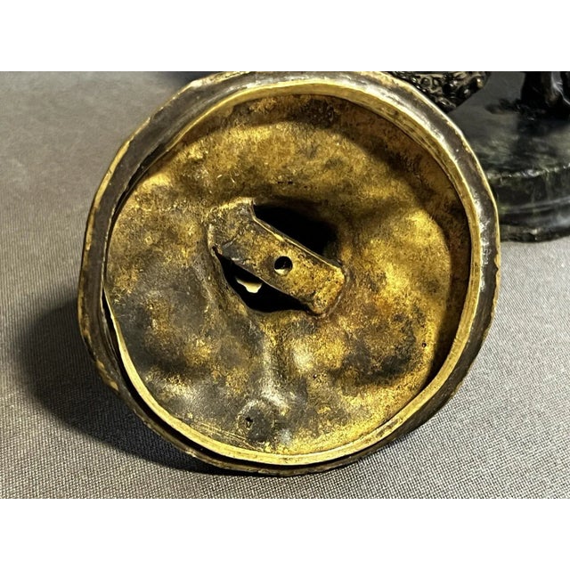 Metal inkwell measuring 19 cm. high, base diameter 13 cm. One of the legs has been glued and all are fixed to the base....