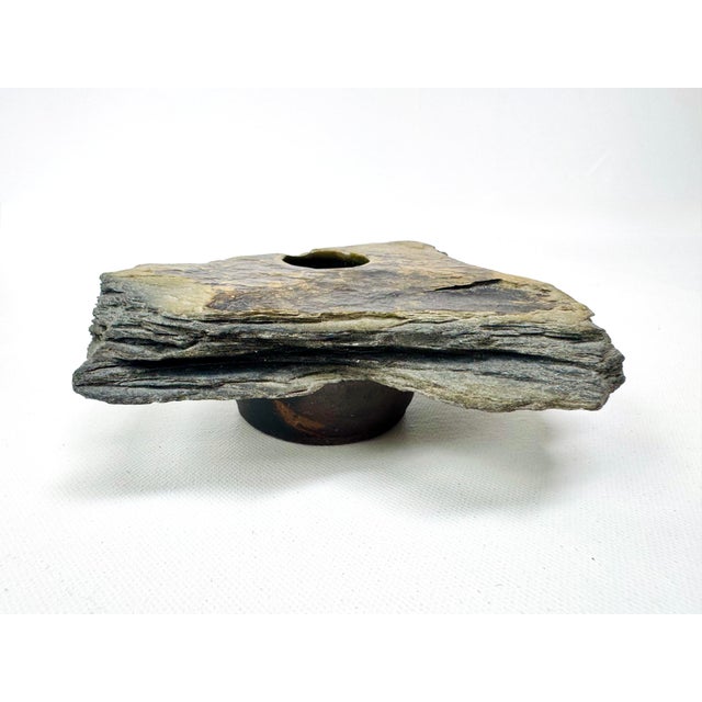 A vintage ikebana vase formed from a rugged slab of layered natural slate. A recessed ceramic insert holds a fixed metal...