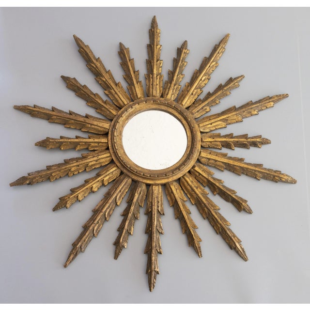 A stunning large antique early 20th Century French giltwood sunburst mirror, circa 1910. This gorgeous mirror is hand...