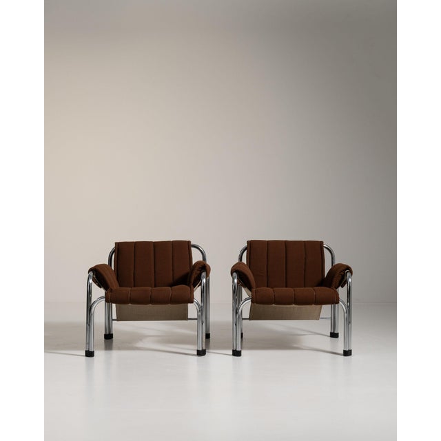 Pair of chrome-frame lounge chairs in Deep Espresso Brown. The deep espresso brown surface highlights tubular chrome...
