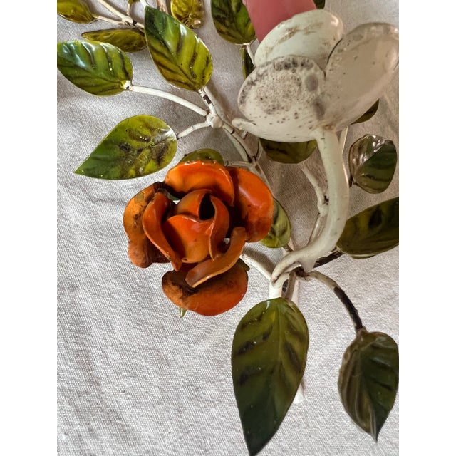 A lovely pair of vintage rose tole sconces. One has pink rose and the other has orange roses. the one with the pink roses...