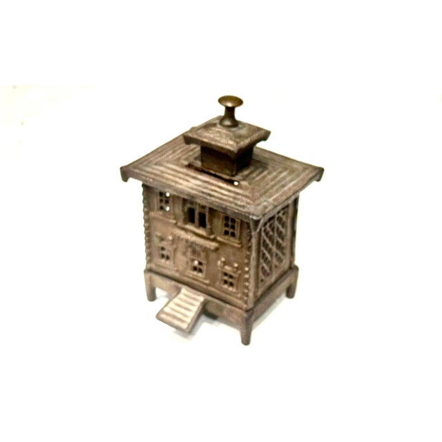 * Material: It is made of cast iron. * Design: The bank features an architectural building design with detailed windows...