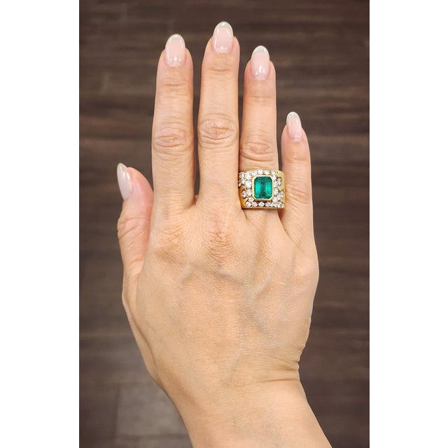This exquisite 18k yellow gold ring showcases an approximate 3.50-carat natural emerald-cut emerald, exuding a rich green...