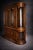 A monumental mid-century Colonial Revival oak china cabinet featuring curved glass display ends, original glass shelving,...
