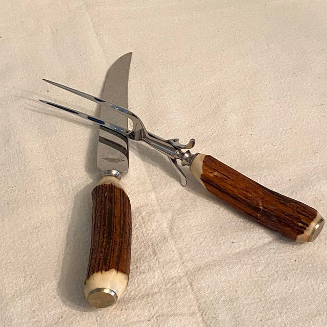 Knife and Fork carving cutlery with stag handles. Fork 101/2” long x 1 3/4 wide, knife is 12 3/4" long X 1 1/4" wide....