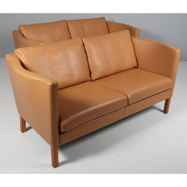 Arne Vodder two seat sofa in original light beige leather. Legs of oak. Made by Nielaus, model AV59 This piece is...