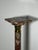 A striking antique marble pedestal featuring richly veined red and pink marble with elegant gilt bronze capitals and base...