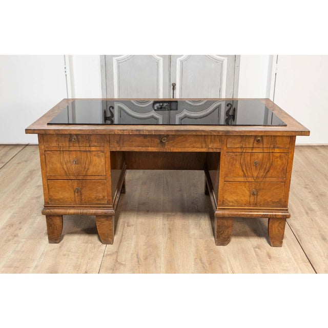This stunning 20th-century Italian desk features a sleek glass top that adds a modern touch to its classic design. The...