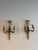 Pair of French Gilded Iron Sconces, circa 1900, each featuring two gracefully curved arms and an elegant bow motif. With...