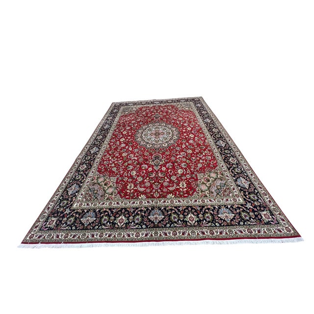 Fine Persian Tabriz rug, hand knotted in Iran with a 100% wool pile and silk highlights. Measuring 9’11” x 13’2”, this...