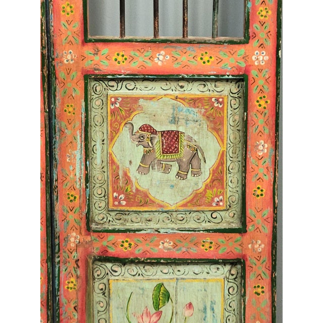 A charming pair of antique Indian teak "dog gates" with iron bars from the early 20th century that were skillfully...