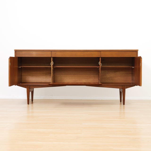 Designed and manufactured by Elliotts of Newbury, this beautifully crafted mid-century sideboard is an elegant example of...