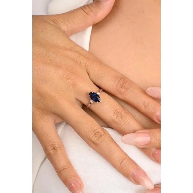This is part of Chairish’s Fine Jewelry assortment. Marquise Cut Blue Sapphire Diamond Three Stone Engagement Ring in 14K...