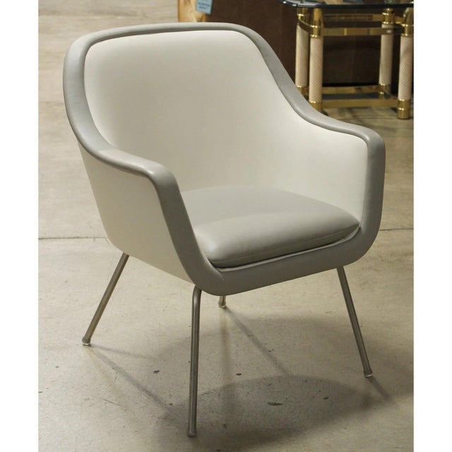 This piece features a smooth, continuous silhouette with rounded arms and a gently curved back that creates a clean,...
