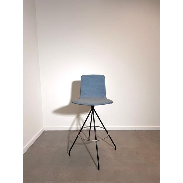 Stylish modern bar stool by Viccarbe, featuring a sleek upholstered shell seat in a sophisticated blue-grey fabric. The...