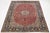 This vintage Persian Isfahan red wool rug features a stunning rosette motif in beige and blue. This rug measures 9'11" x...