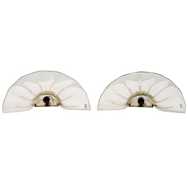 Pair of Mid-centutry Italian wall light sconces handmade in Murano glass and brass base by Seguso. Murano glass is...