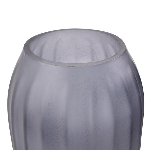 A stunning hand-blown glass piece featuring a sleek, ribbed design and a graceful ombre finish. The vase transitions from...
