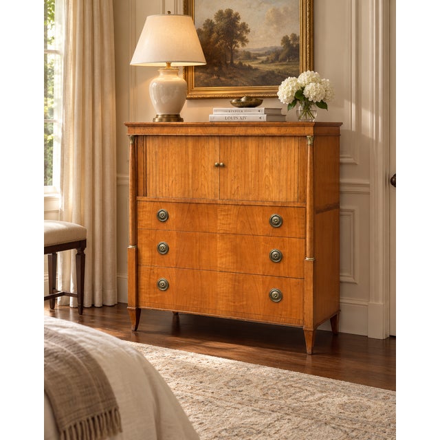A handsome vintage Baker Furniture gentleman’s chest with refined Neoclassical detailing, warm wood tones, and a highly...