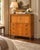 A handsome vintage Baker Furniture gentleman’s chest with refined Neoclassical detailing, warm wood tones, and a highly...