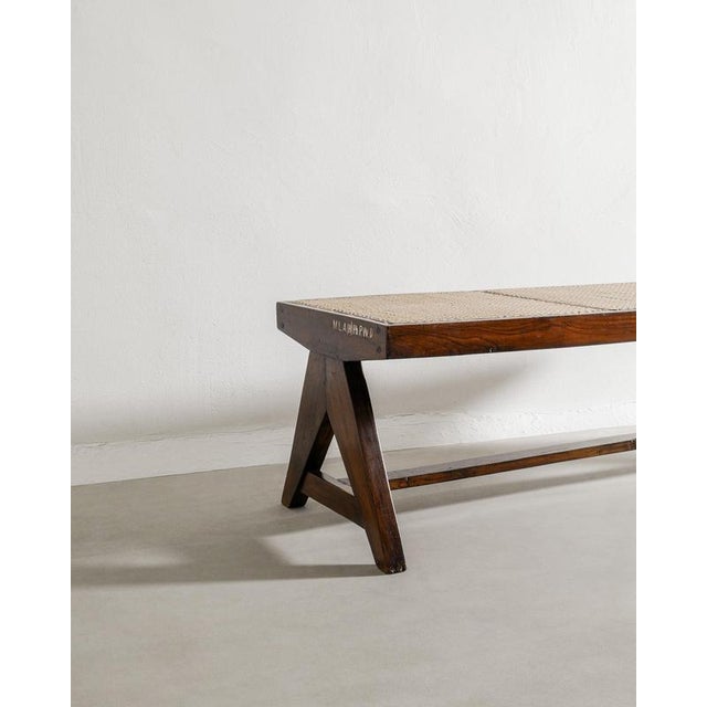 Rare French mid century wooden bench in dark stained teak and natural colored rattan with a nice lettering on one of the...