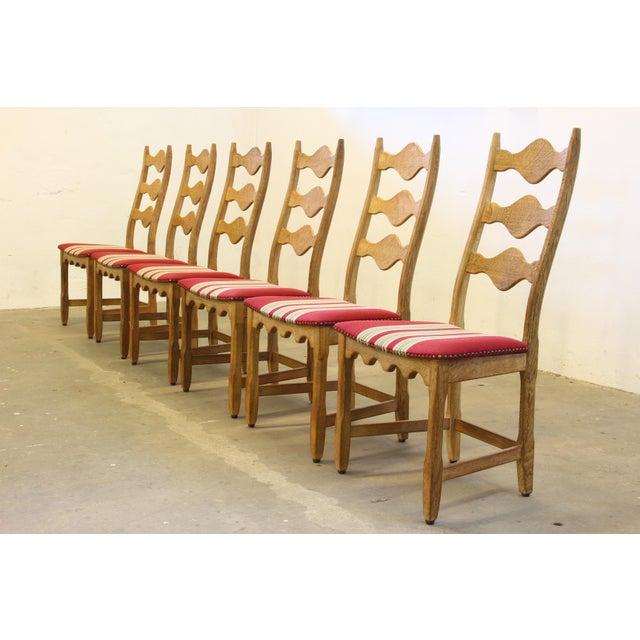 This set of 6 carved light oak ladder-back chairs, familiar to the "Razorblade" model, designed by Henning Kjærnulf....