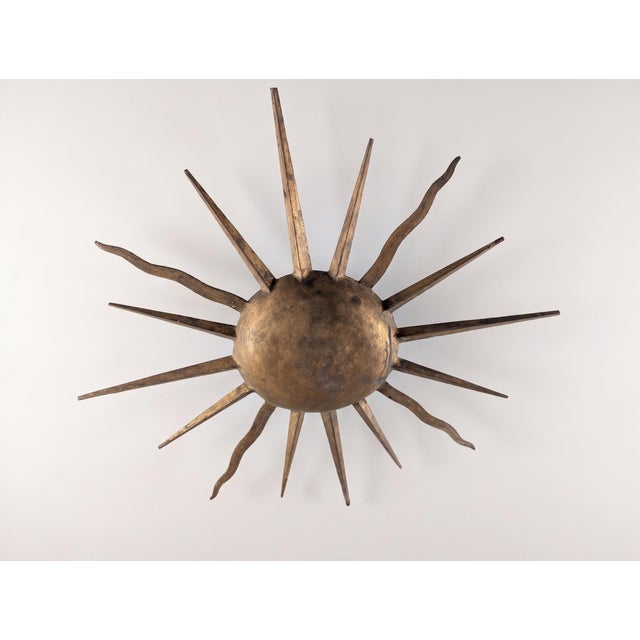 This flush mount ceiling lamp takes the form of a sunburst, a motif closely associated with Mid-Century Modern lighting...