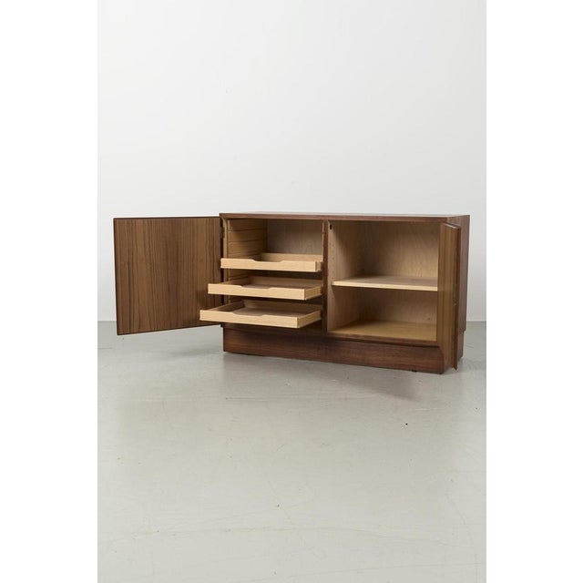 Vintage Danish sideboard by Poul Hundevad from Denmark. The cabinet is made of teak veneer. Has two doors with a lock and...