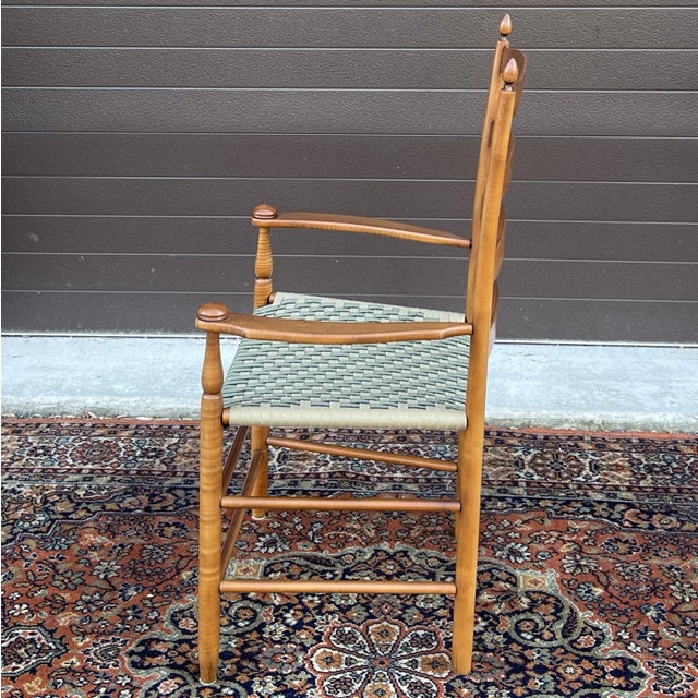 An early 21st century American Shaker style solid maple ladder back armchair with a teal & tan webbed seat. Hand crafted...
