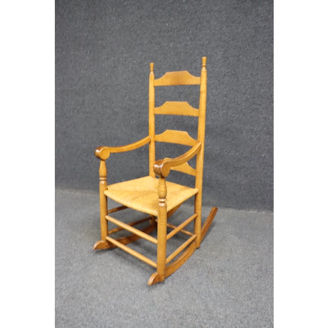 Tiger maple rocking chair with rush seat.