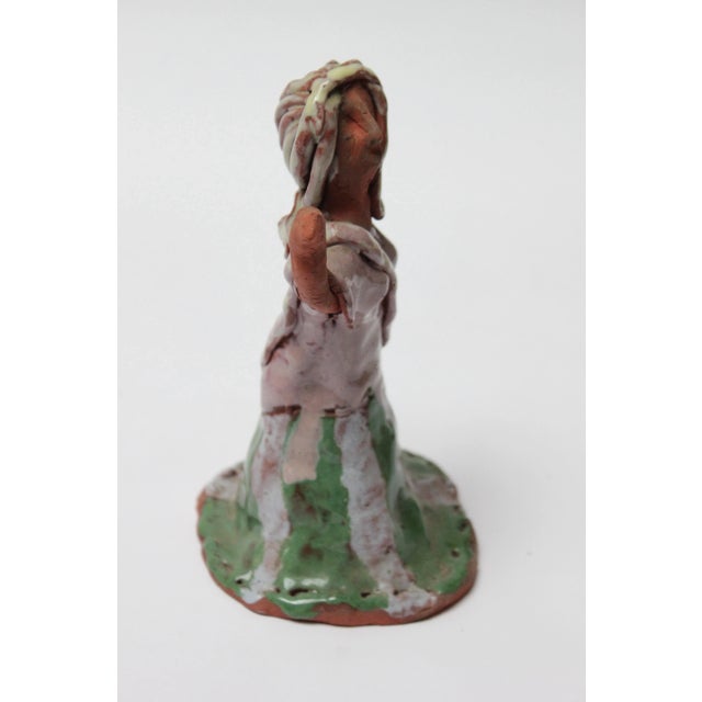 Charming terracotta sculpture depicting a dancing woman. Crude, unrefined work in the naïve style with attractive pops of...