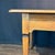 Refined antique French side table or petite desk crafted in warm fruitwood with a beautifully figured rectangular top and...