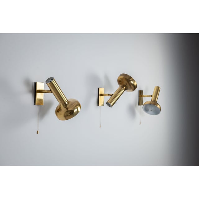 This refined set of three vintage brass wall lamps exemplifies understated luxury and sculptural design. Each piece is...