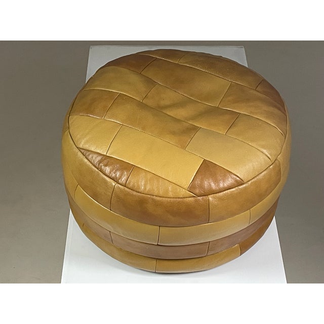 Brown leather pouf by Swiss designer De Sede with a square patchwork design. Very good overall condition. Dimensions:...
