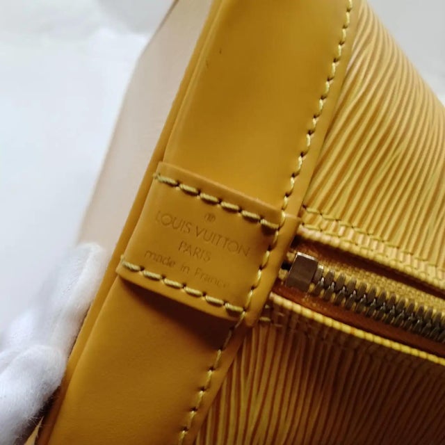 This stunning Louis Vuitton Alma PM is a vibrant piece of fashion history, crafted in the house's signature textured Epi...