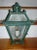 An exceptional iron wall sconce with original green paint in the form of a half lantern containing a single candle light....