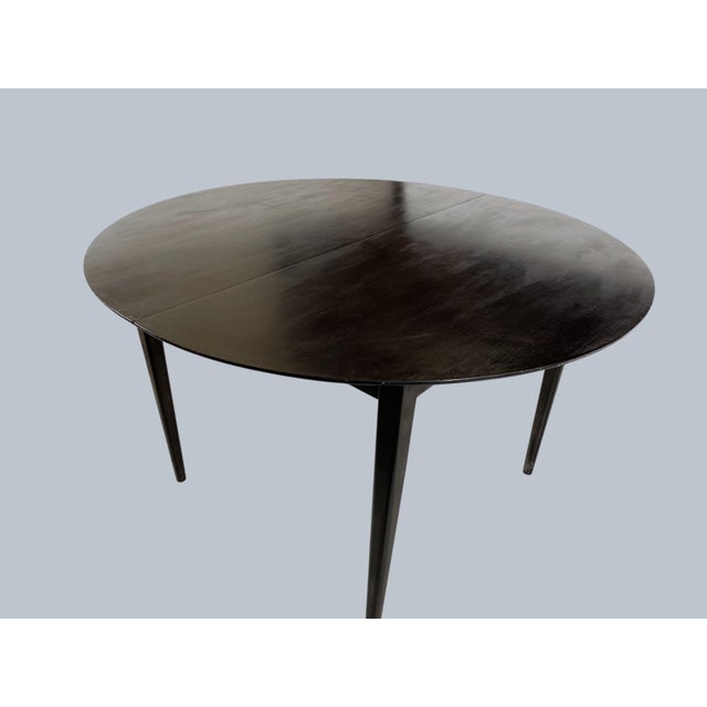 A mid-century dining table with two extensions. 87.25"W, 45"D, 28.75"H.