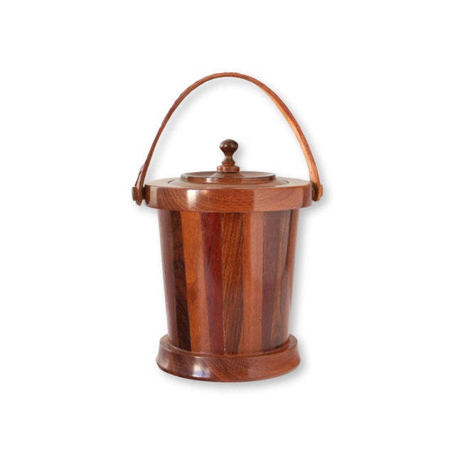 A handsome midcentury wooden ice bucket featuring a beautifully crafted staved wood design with rich grain variations. The...