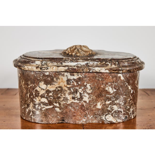 Elegant, bow front, lift top, hand carved marble box with two, round compartments. The sinuous base is mirrored in the...