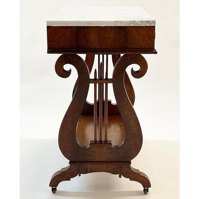 Extra gorgeous antique mahogany lyre table with marble top, drawer slides excellent and casters function great as well....