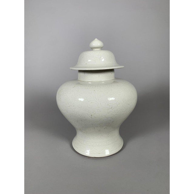 Early Qing Dynasty porcelain vase, 18th century. This monochrome cream-white porcelain vase is incised under the glaze...