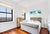 Elegant grey velvet sleigh bed has deep button tufting on headboard. Frame is fully upholstered with rolled footboard and...