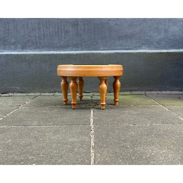 Overbuilt stool in turned pine featuring 6-leg construction and a small circular seat in black leather. Unknown...