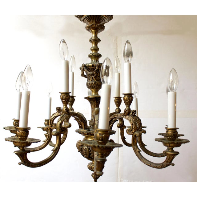 Circa 1900 French cast bronze 12-light chandelier, Louis XIV style. Baroque influence C-scroll based form, the whole...