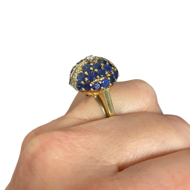 Vintage bombe style ring crafted in 14K yellow gold, the ring features a dome of round blue sapphires accented with...