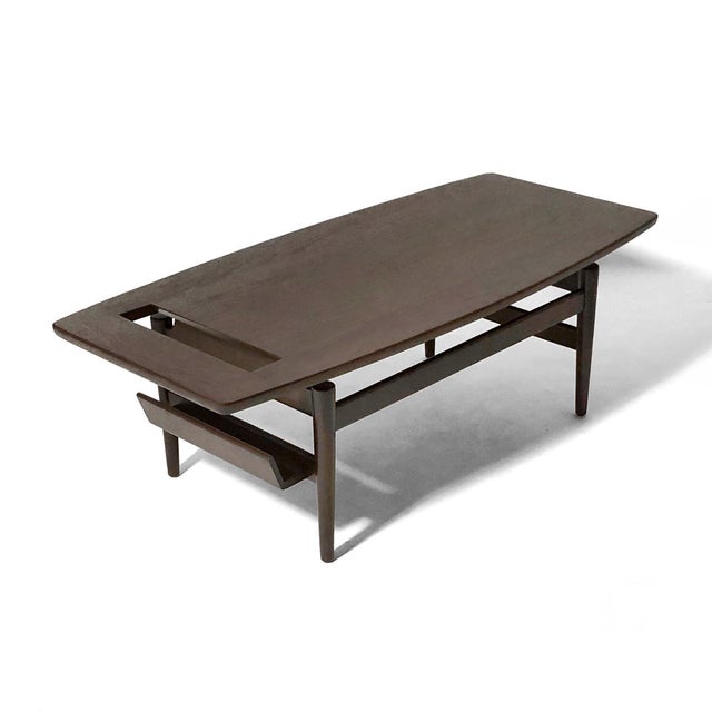 This uncommon model T 390 walnut coffee table by Jens Risom has a beautiful soft boat shape to the top which appears to...